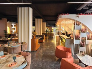 Et moderne interiør med siddeområder, en bar og en reception.