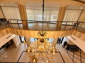 A grand chandelier in a spacious lobby with a high ceiling and large windows. - Royal Grand Hotel (Monrovia)