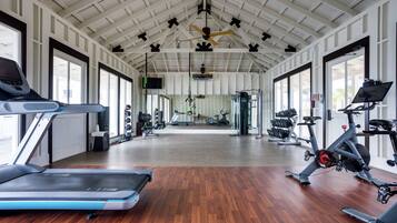 Un gimnasio con cintas de correr, bicicletas estáticas y máquinas de pesas.