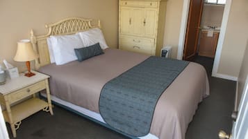 Une chambre à coucher avec un lit, une table de chevet, une lampe et une armoire.