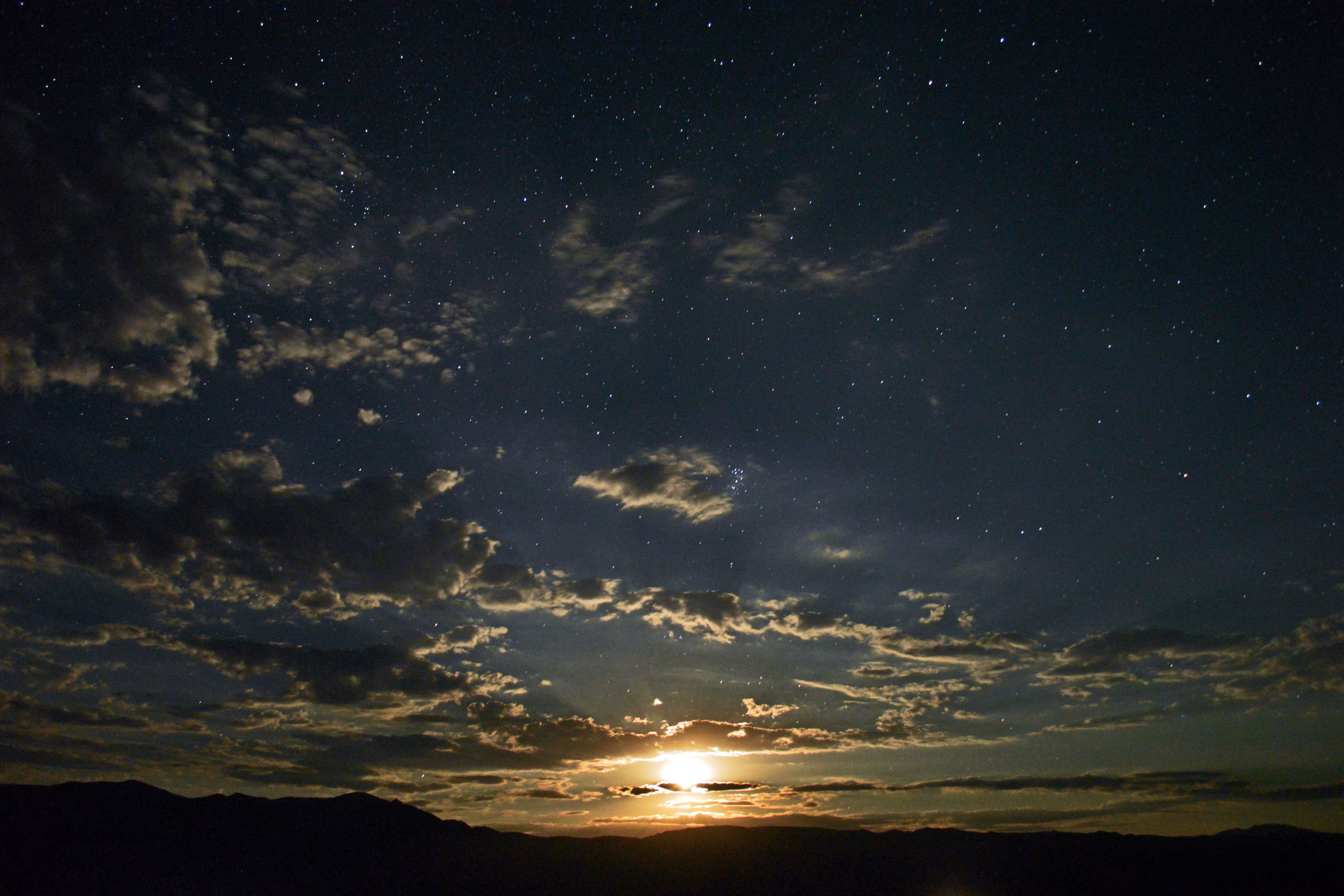 A night sky with stars and clouds.