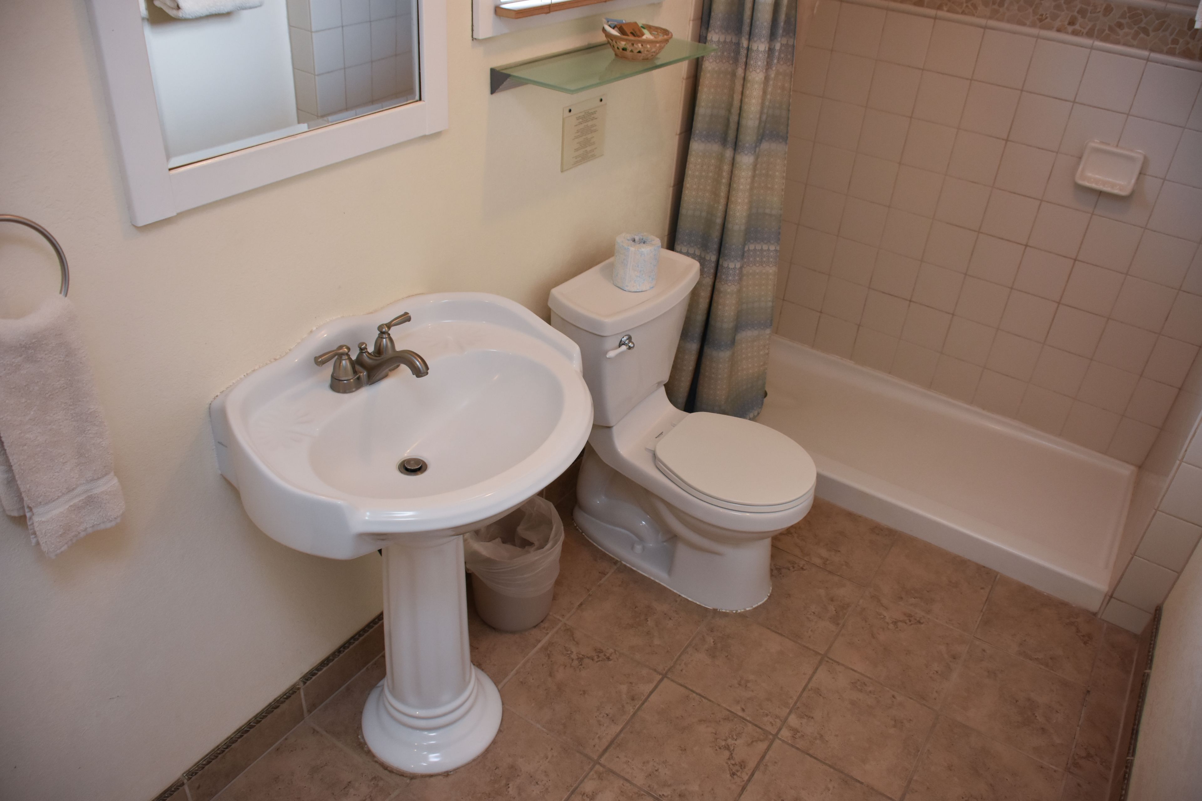 A bathroom with a pedestal sink, toilet, and bathtub.