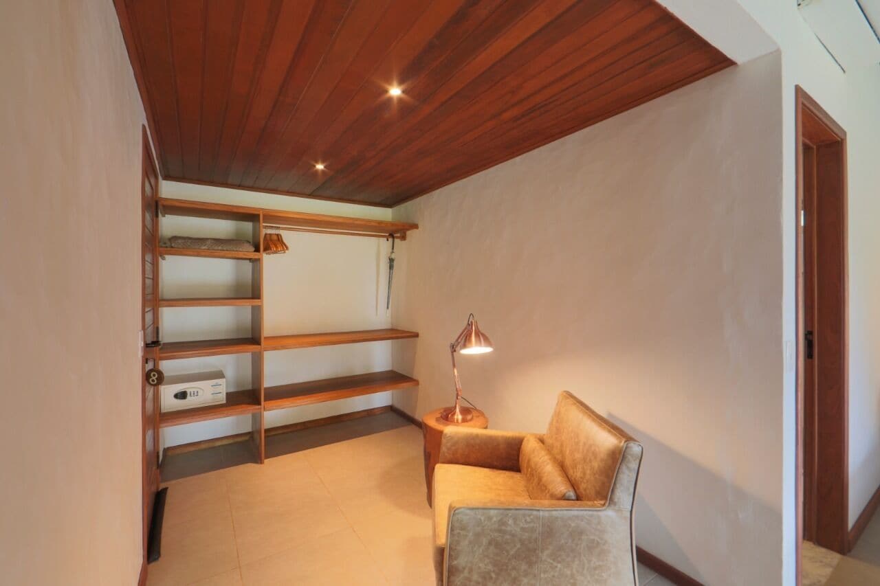 Una habitación con techo de madera, un sofá, una lámpara y estantes empotrados.