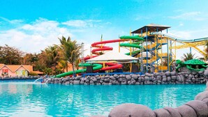 Un parc aquatique avec une piscine, des toboggans et une aire de jeux.