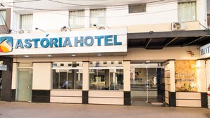 Un hôtel appelé « Astória Hotel », doté d’une façade moderne, de grandes fenêtres en verre et d’une entrée bien visible.