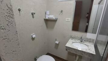Un baño pequeño con inodoro, lavabo y espejo.