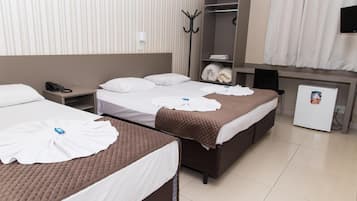 A hotel room with two beds, a wardrobe, a coat rack, a telephone, and a small refrigerator.
