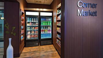 Un negozio di alimentari all'angolo con vetrine refrigerate per bevande e scaffali pieni di snack.