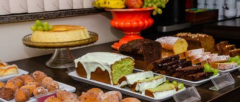 A buffet with various desserts, including cakes, brownies, and doughnuts.