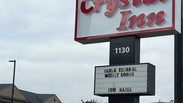 A hotel sign with 'Crystal Inn' and '1130' indicating the address.