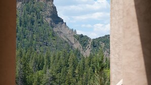 Vista de una montaña con un banco de madera y una estatua de león de piedra en primer plano.