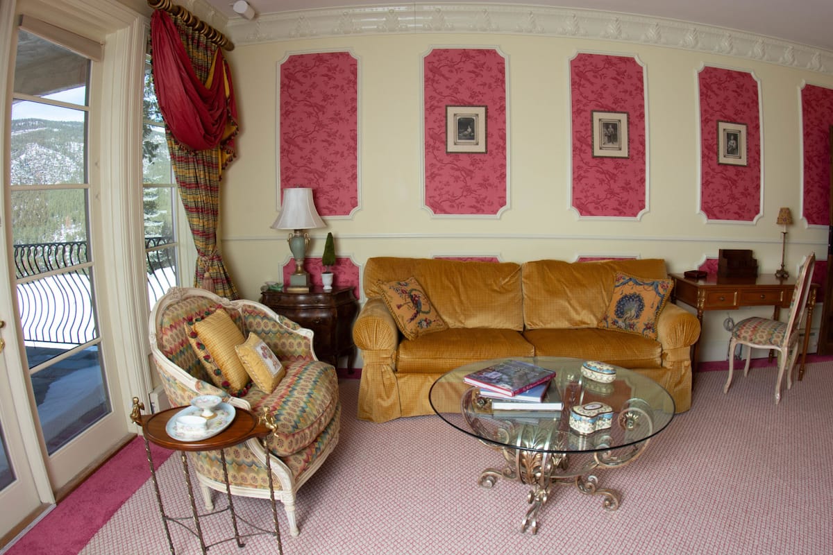 A cozy living room with a sofa, armchair, and a glass coffee table.