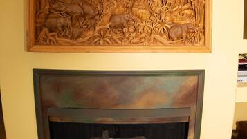 Un pannello in legno intagliato e un camino con una scultura in pietra.