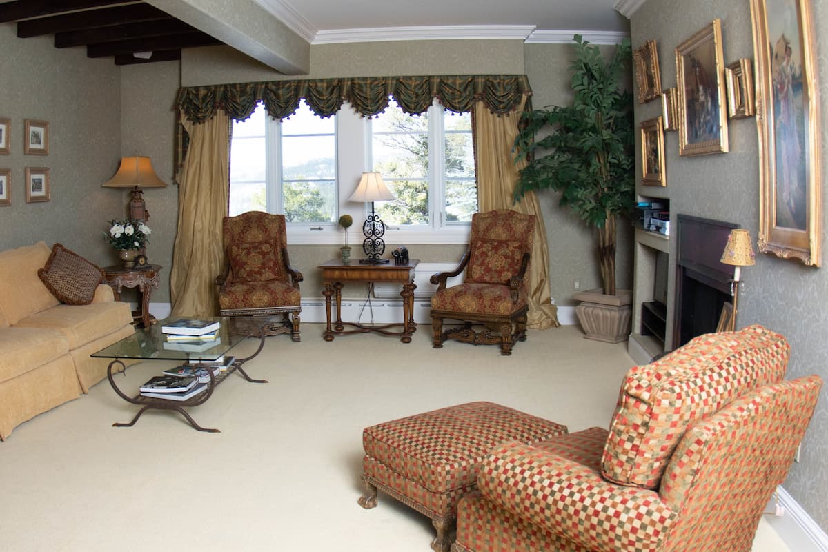 A traditional living room with a sofa, armchairs, a coffee table, and a fireplace.
