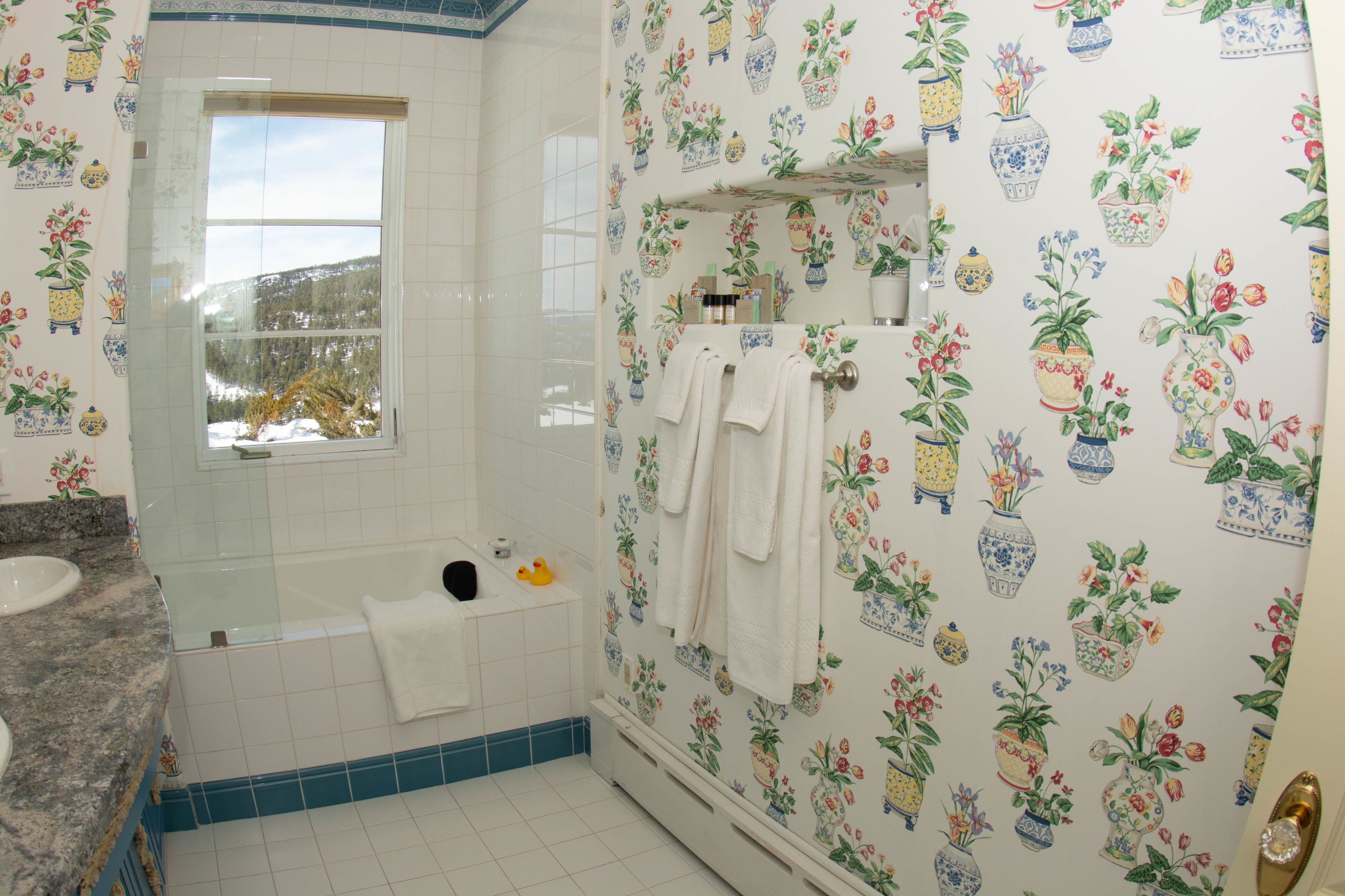 Une salle de bain avec une baignoire, une fenêtre et un lavabo.
