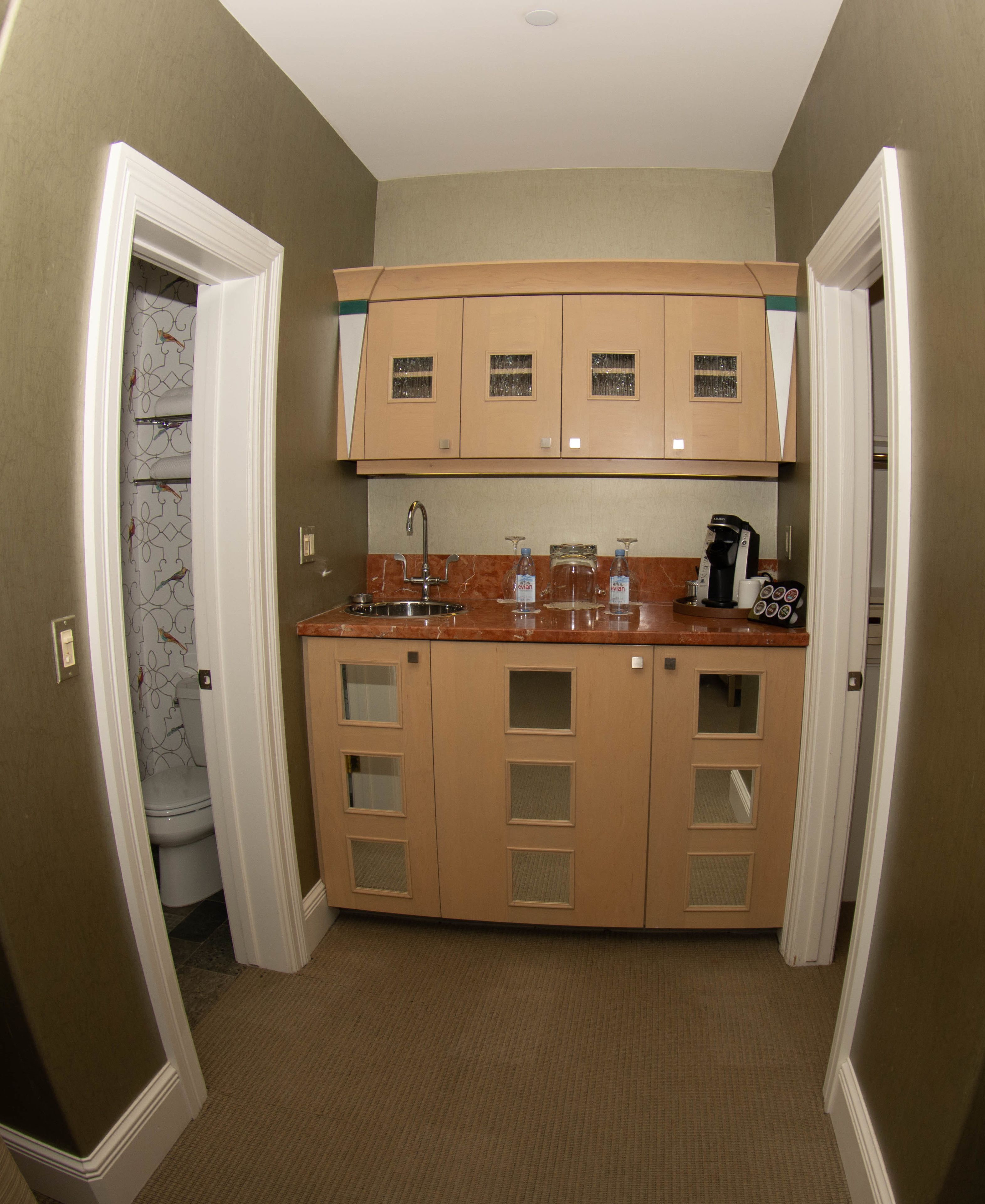 A compact kitchen with a sink, faucet, and a coffee maker.