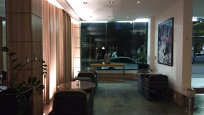 Ein modernes Interieur mit Holzvertäfelung, einer Glaswand mit Blick auf die Straße und Sitzgelegenheiten.