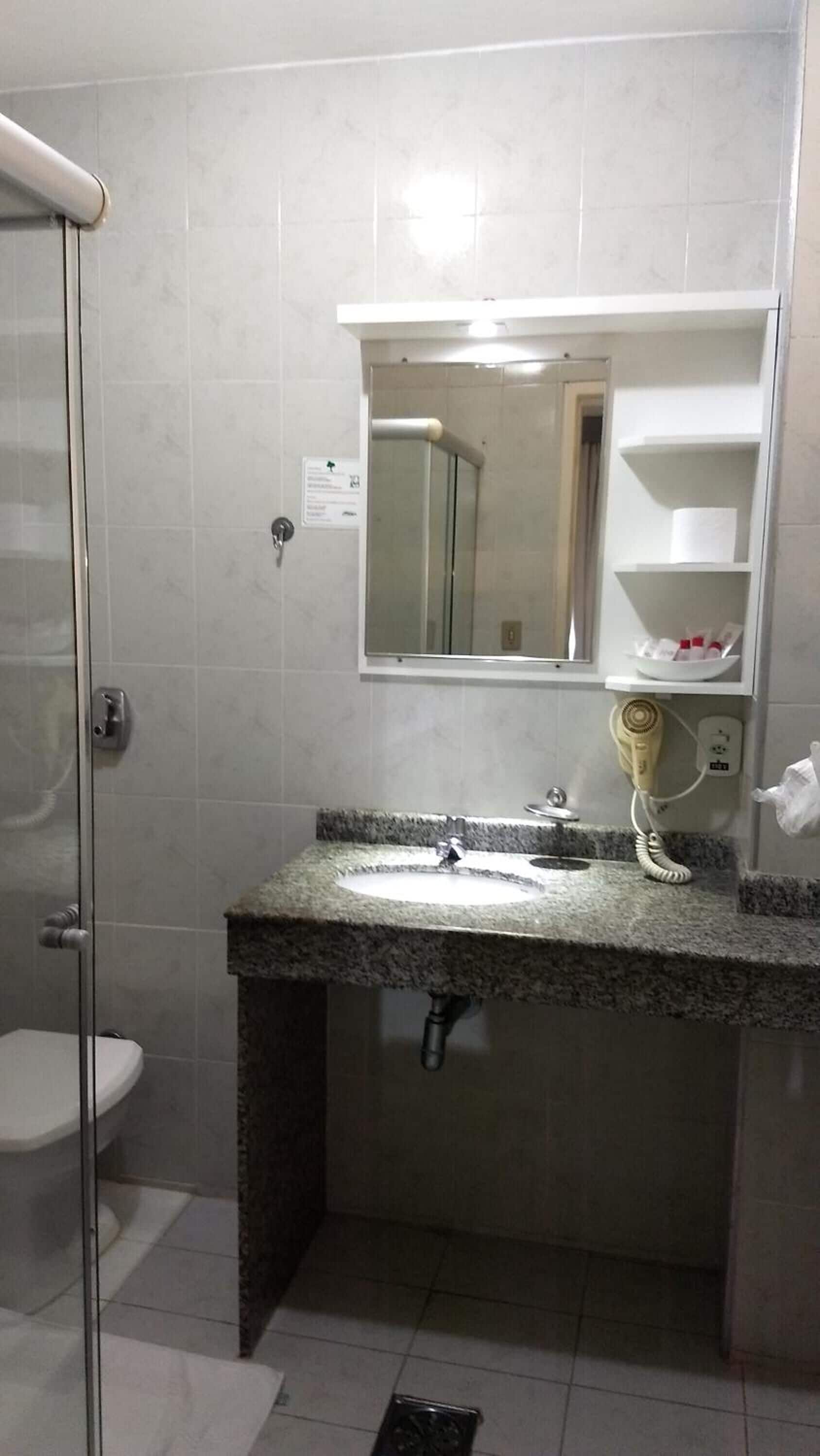 Un baño con ducha, inodoro y lavabo.