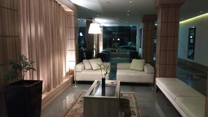 Ein modernes Wohnzimmer mit einer Couch, einem Couchtisch und einer Zimmerpflanze.