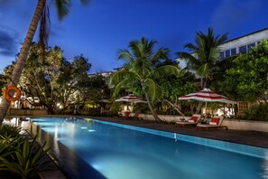 Una piscina al aire libre, sombrillas, tumbonas