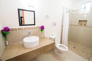 A bathroom with a sink, toilet, and shower.