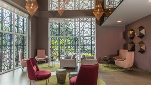 Een moderne lounge met grote ramen, comfortabele zithoek en sfeervolle verlichting.