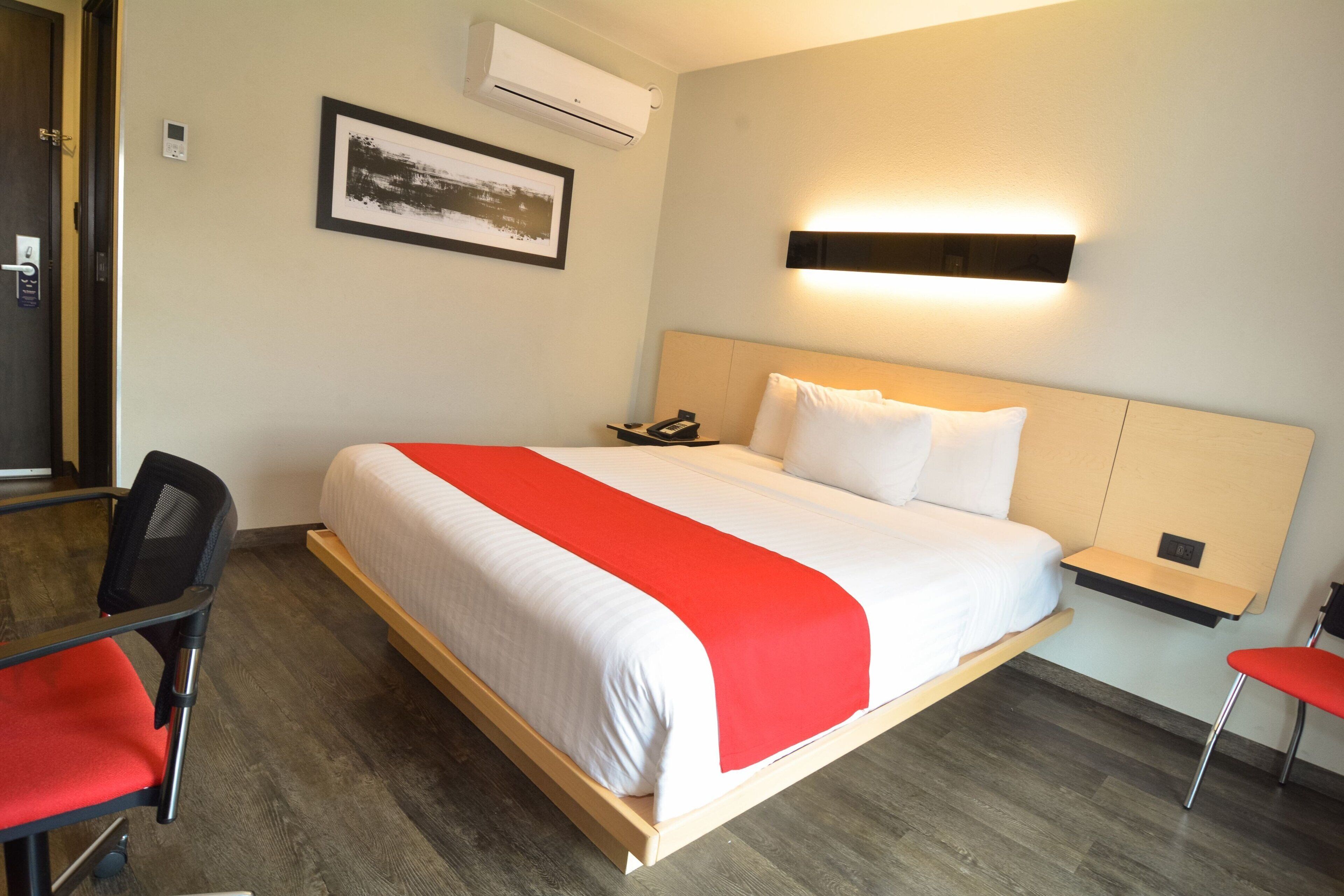 Una habitación de hotel con una cama grande, un escritorio y una silla.