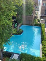 Una piscina al aire libre, sillones reclinables de piscina