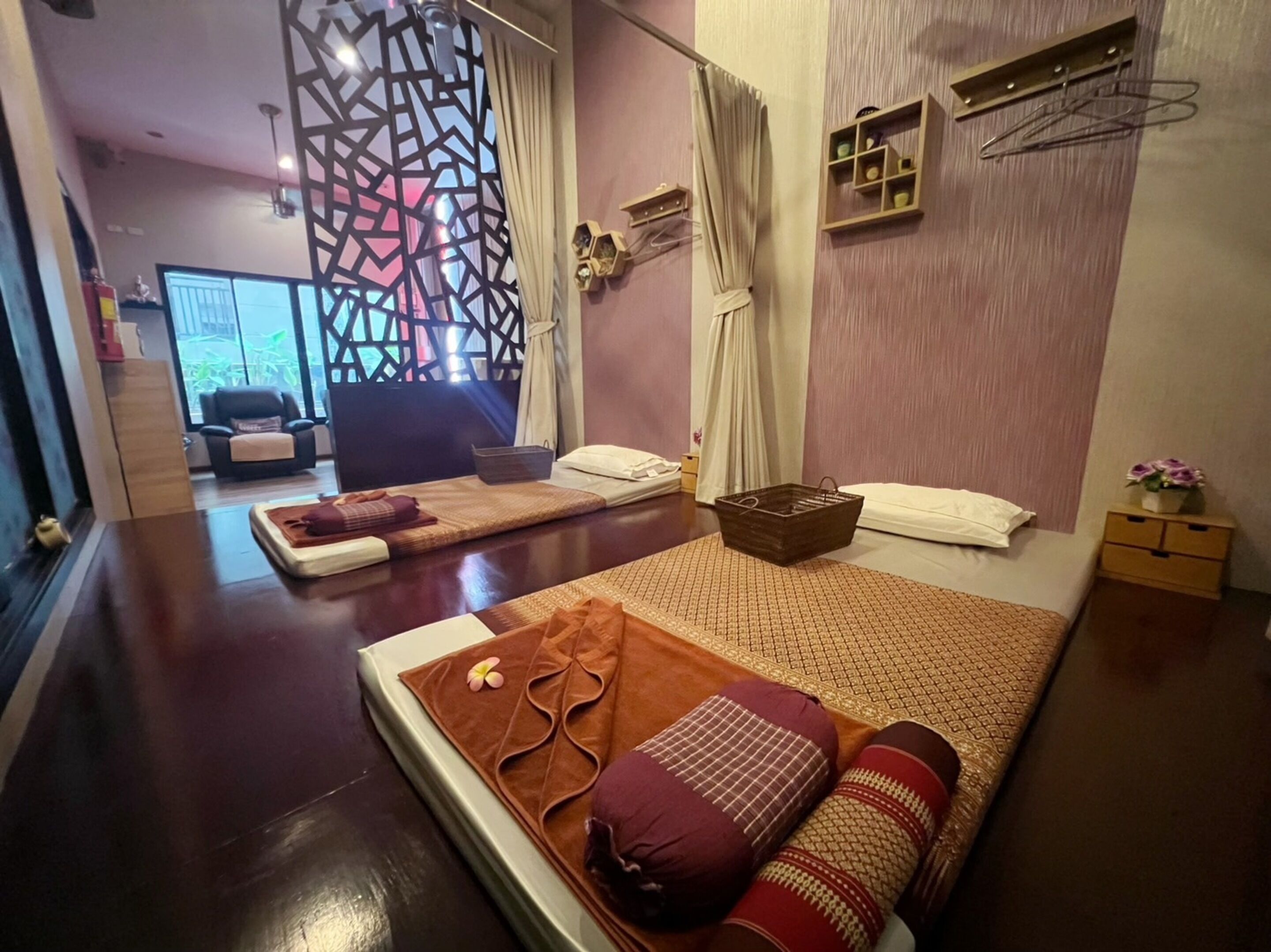 Une salle de spa moderne équipée d’une table de massage, de serviettes, d’un panier et d’un panneau décoratif mural.