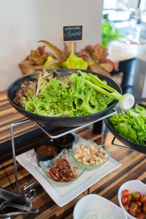 A salad bar with various greens and toppings.