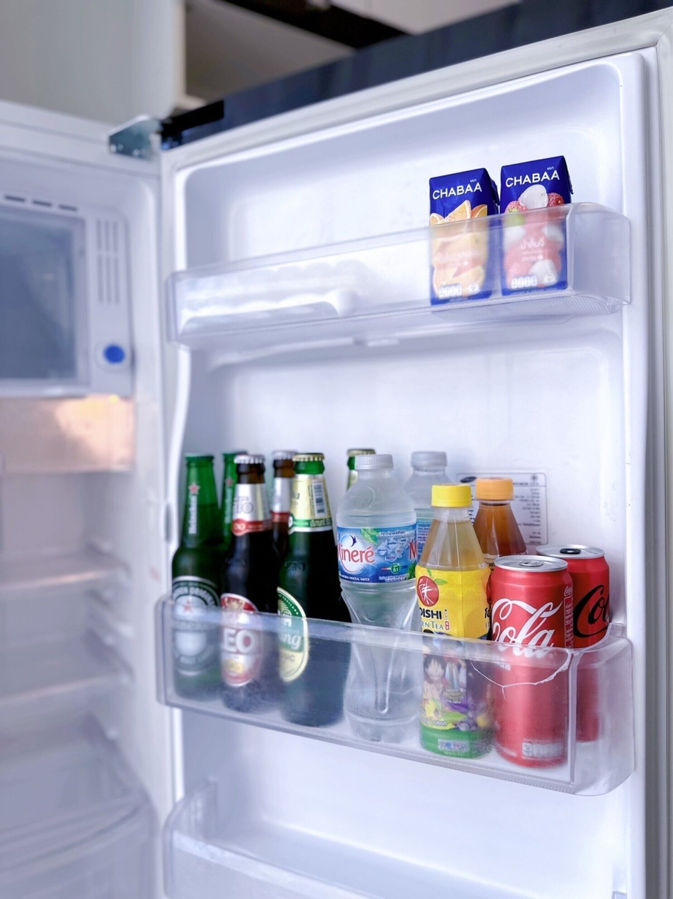An open refrigerator with various beverages including beer, soda, and juice.
