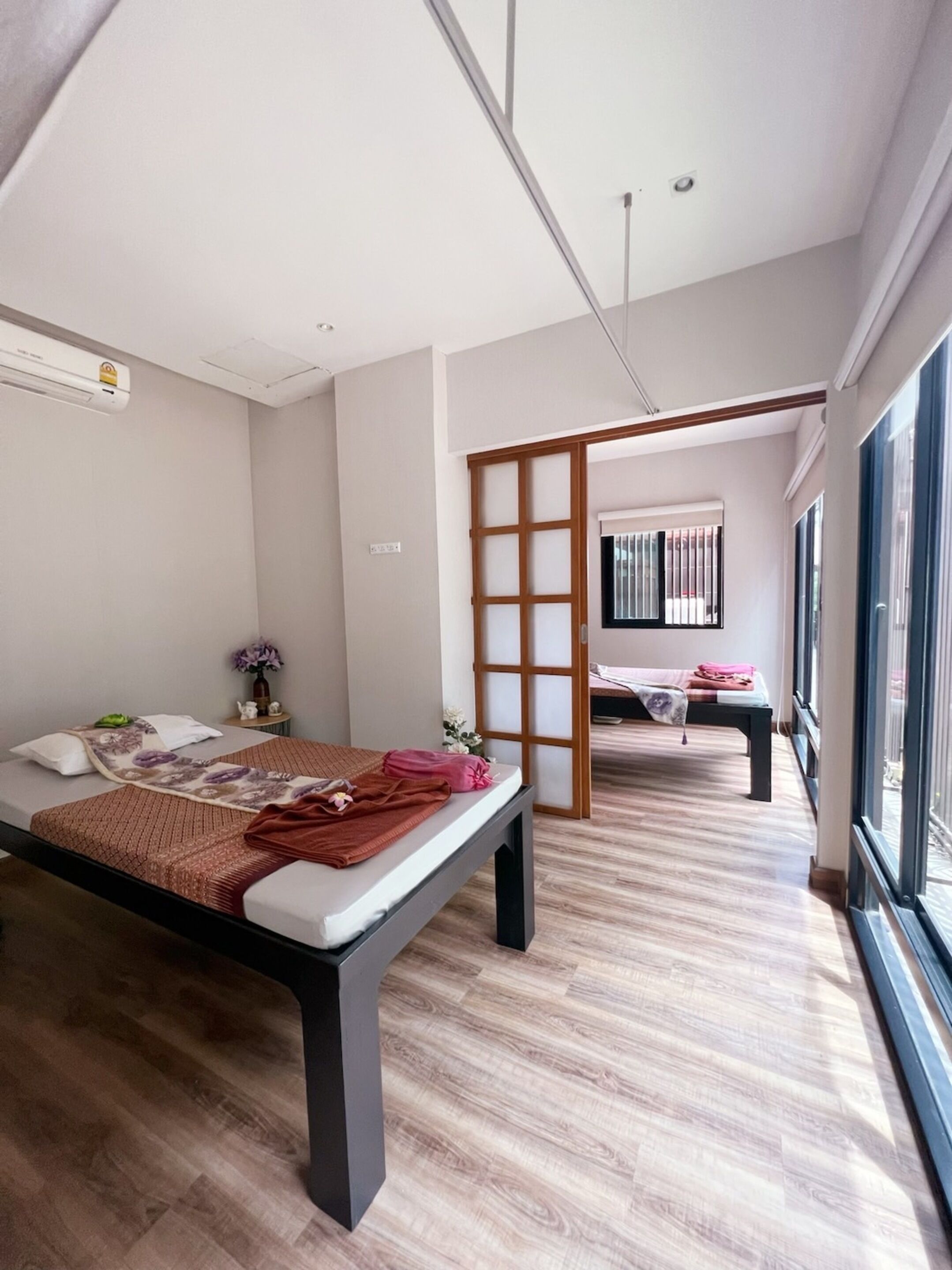 Een moderne slaapkamer met een bed, een tafeltje en een raam.