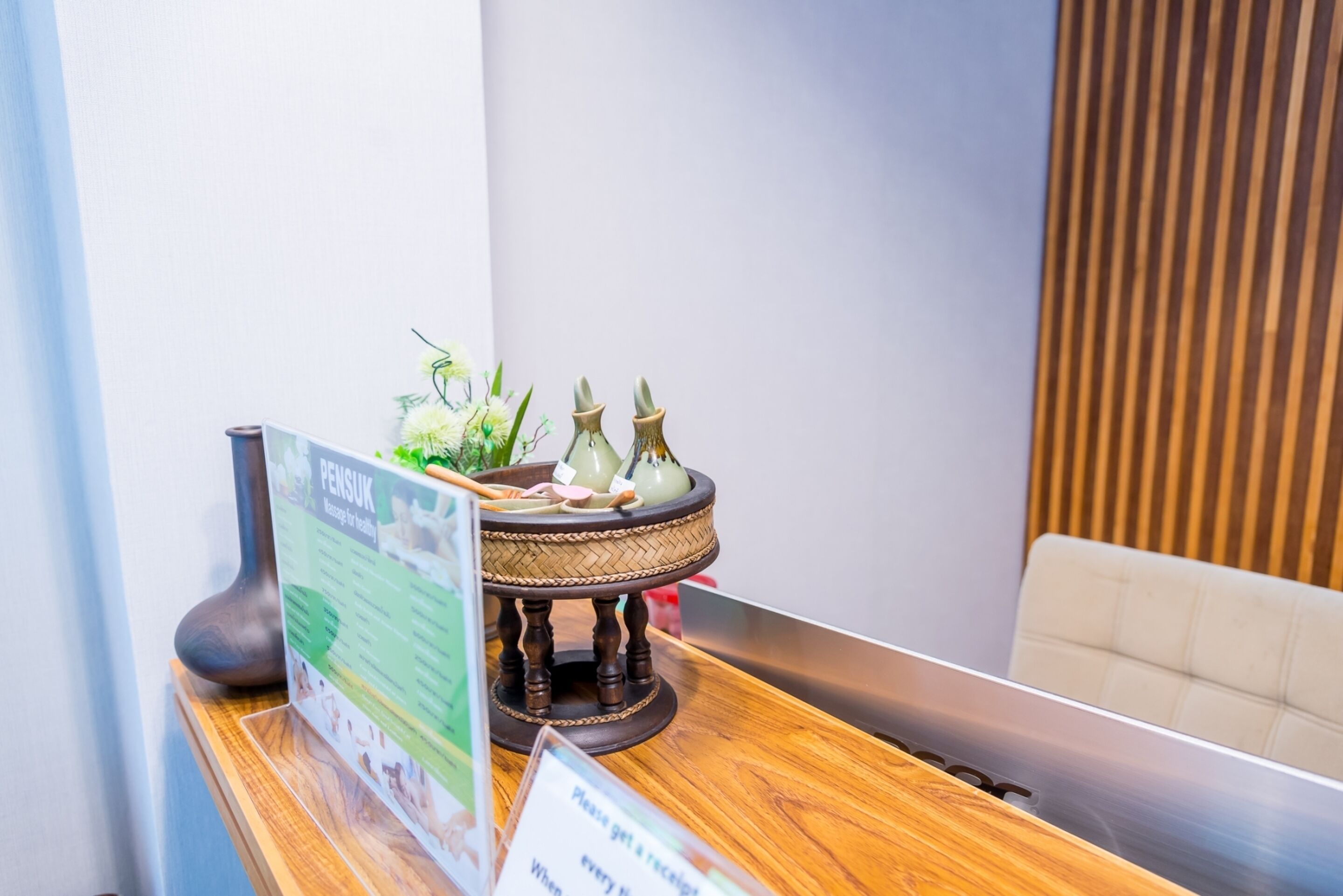A reception area with a wooden counter, a menu stand, and a decorative tea set.