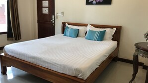 A neatly made bed with white linens, a wooden headboard, and two pillows with blue stripes. - Baan Ruankaew Resort (Nakhon Ratchasima)