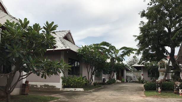 A residential area with houses, a paved driveway, and surrounding greenery. - Baan Ruankaew Resort (Nakhon Ratchasima)