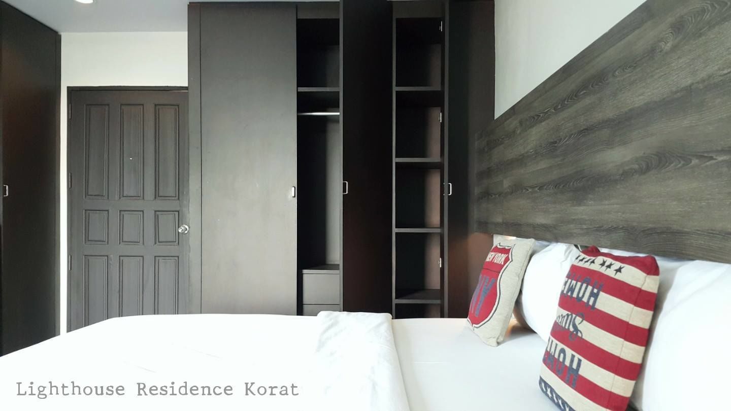 A bedroom with a bed, a wardrobe, and a built-in closet.