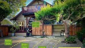 A house with a balcony, a wooden fence, and a sign indicating an EV charger with 40A.