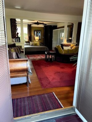 Una habitación de hotel con una cama, un sofá, una alfombra roja y una mesita.