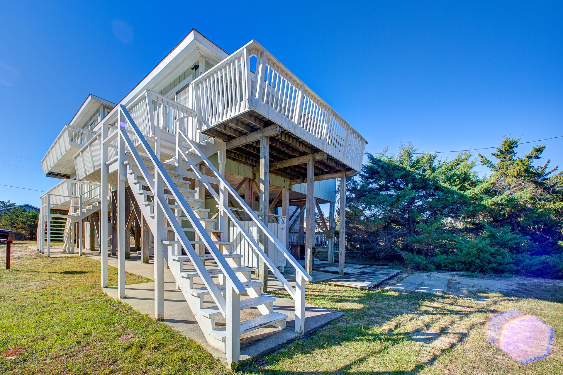 Ein weißes Holzgebäude mit Balkon und Treppe.