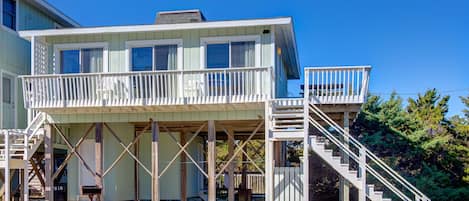 A two-story house with a balcony and a staircase leading to the upper level.