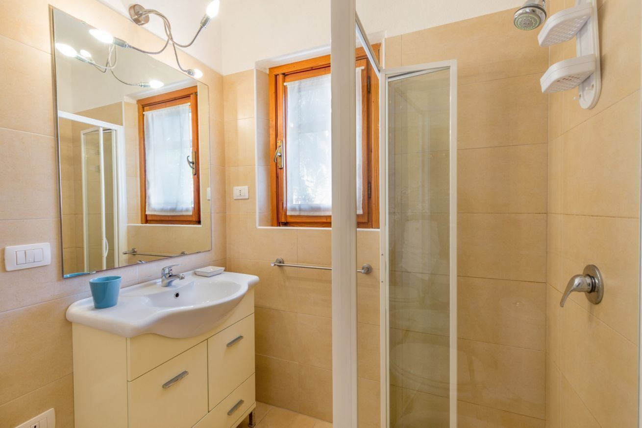 Un baño con lavamanos, espejo y ducha.