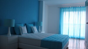 A bedroom with a bed, nightstands, and lamps.