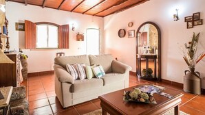A cozy living room with a beige sofa, wooden coffee table, and a large mirror. - Holiday Cottage in the Natural Park  (Alcobertas)