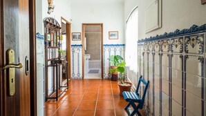 A hallway with a wooden door, a blue bench, and a potted plant. - Holiday Cottage in the Natural Park  (Alcobertas)