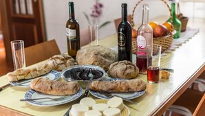 A table with various food items, plates, and bottles of wine. - Holiday Cottage in the Natural Park  (Alcobertas)