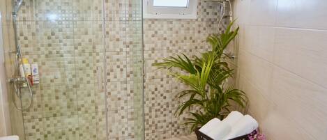 A bathroom with a shower, a toilet, and a sink.