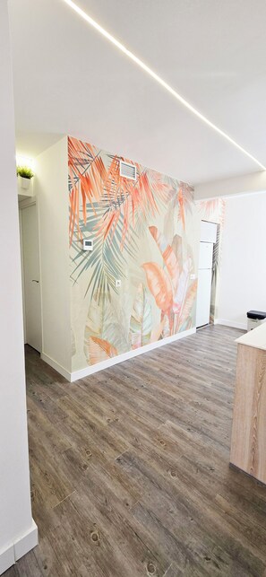 Experience the vibrant tropical atmosphere in this stylish room, featuring a unique wall mural and modern decor.