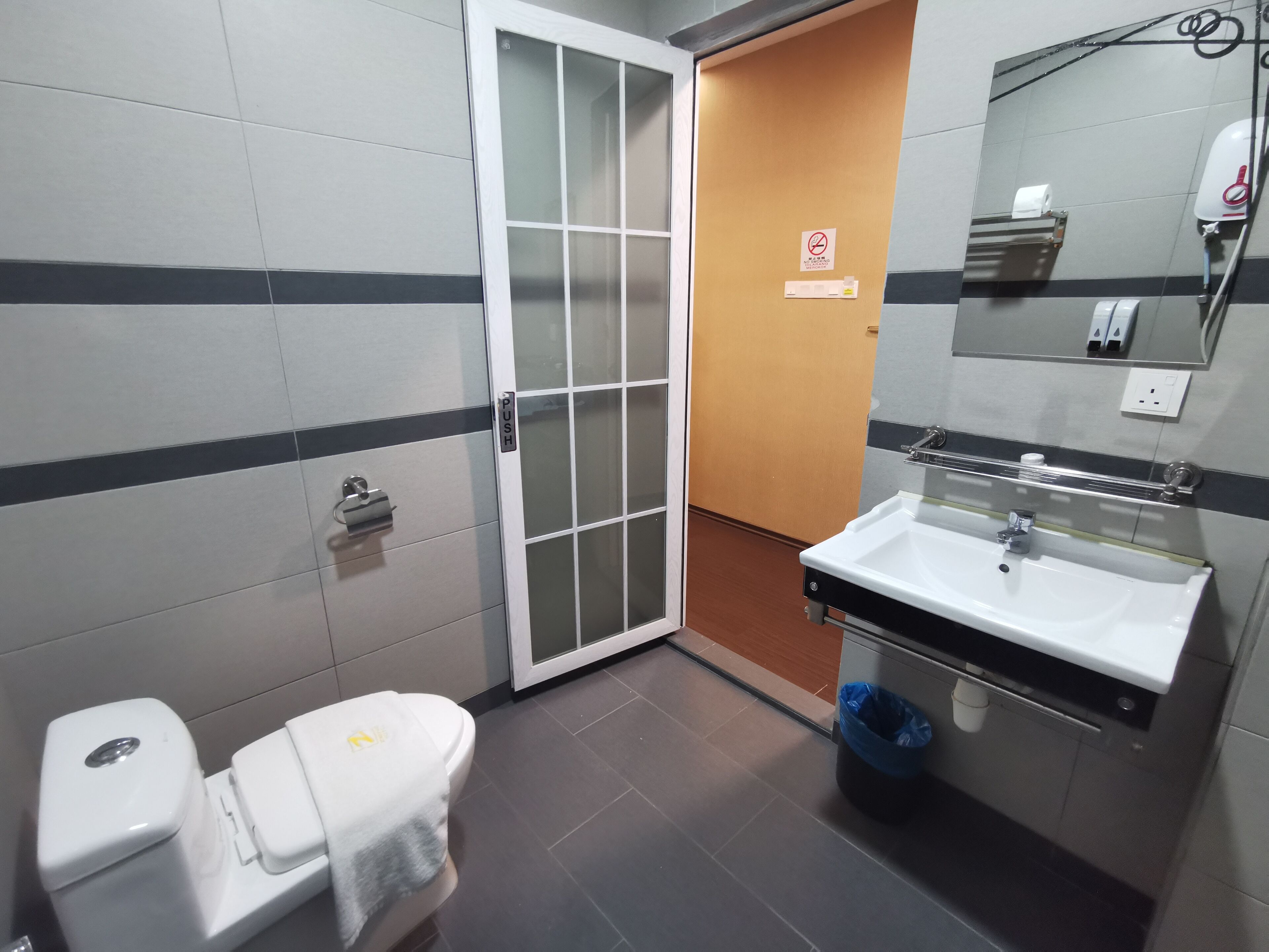 A bathroom with a white sink, a mirror, and a toilet.