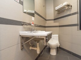 A modern bathroom with a white sink, a toilet, and a towel rack.