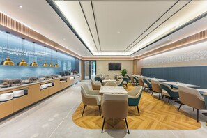 A modern restaurant with a long counter, multiple seating areas, and a decorative wall. - Hangzhou Tian Lin Shang Gao Hotel (Hangzhou)